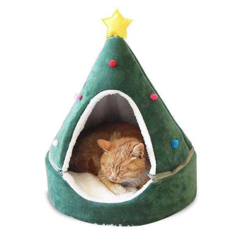 a cat sleeping in a green christmas tree shaped bed