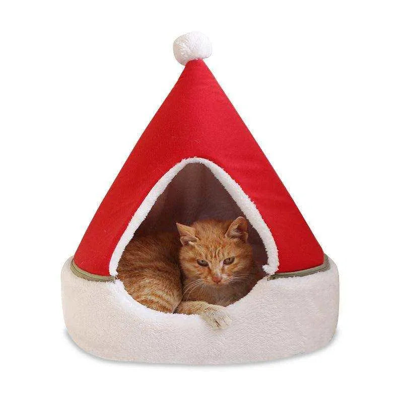 a cat laying in a cat bed with a santa hat on top of it