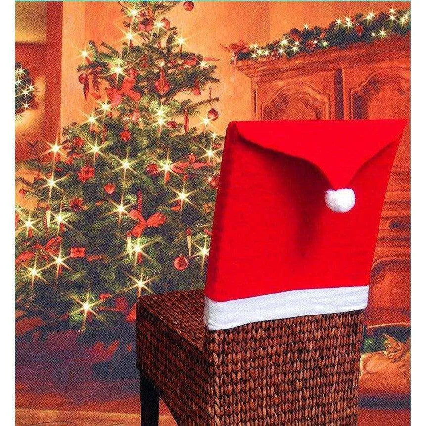 a santa hat sitting on top of a wicker chair next to a christmas tree