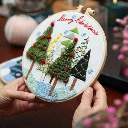 a person holding a hand embroidered christmas tree