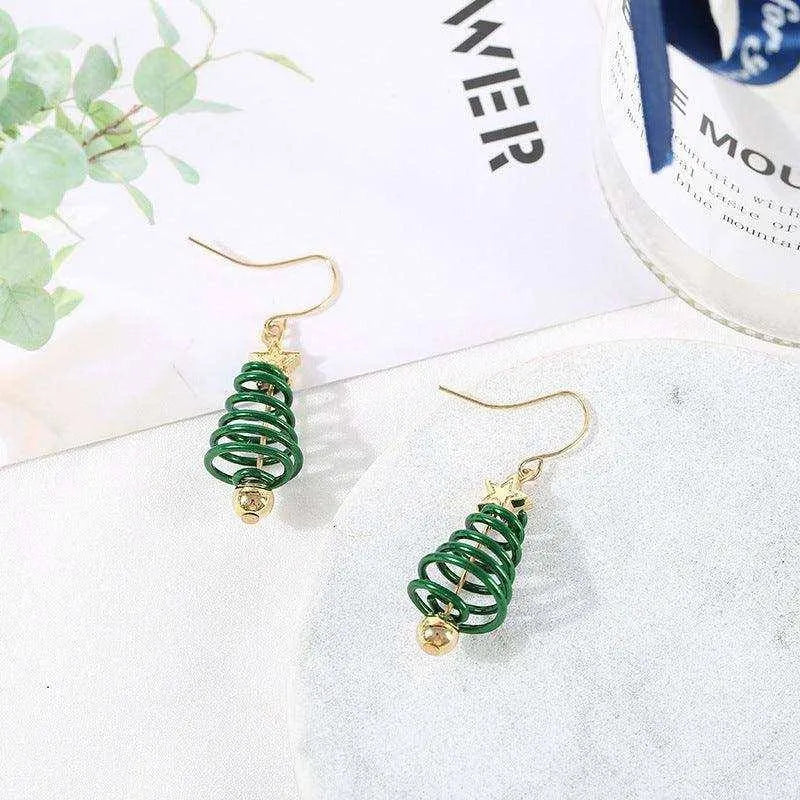 a pair of green and gold earrings sitting on top of a table