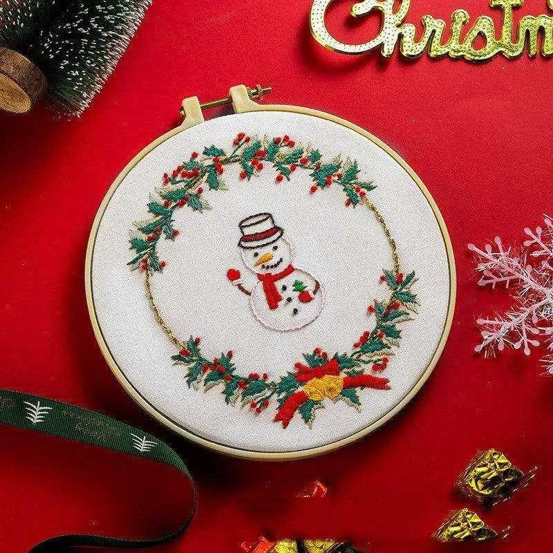 a cross stitch christmas ornament with a snowman on it