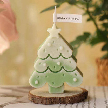 a small green christmas tree candle sitting on a table