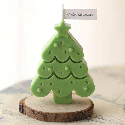 a small green christmas tree sitting on top of a piece of wood