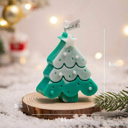 a small green christmas tree sitting on top of a piece of wood