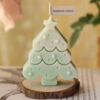 a small green christmas tree sitting on top of a wooden slice