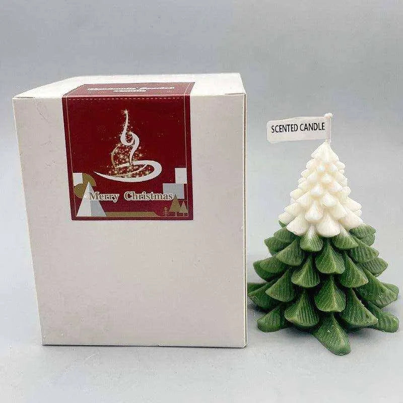 a small christmas tree next to a boxed candle