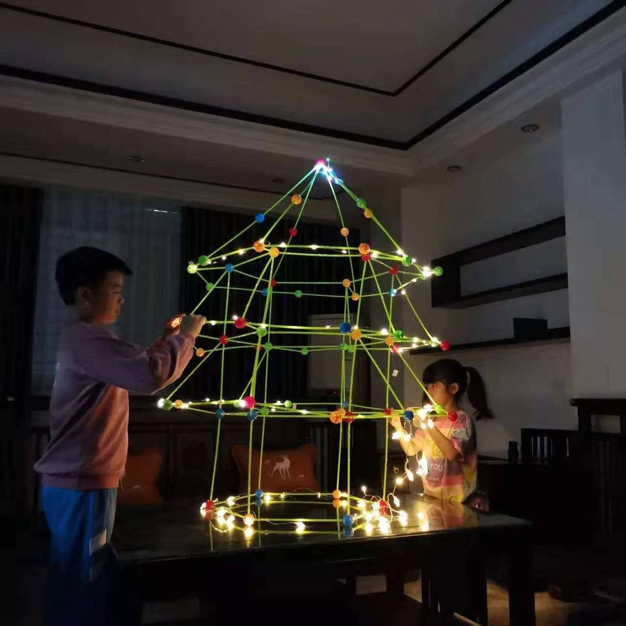 a young boy and girl are decorating a christmas tree