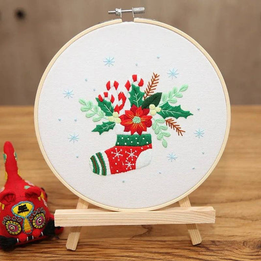 Close-up of embroidery needle and Christmas-themed thread on canvas