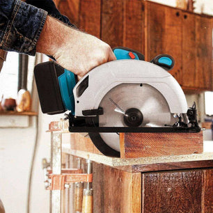 a man using a circular saw to cut a piece of wood