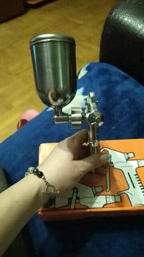 Artist using paint sprayer gun airbrush for model painting